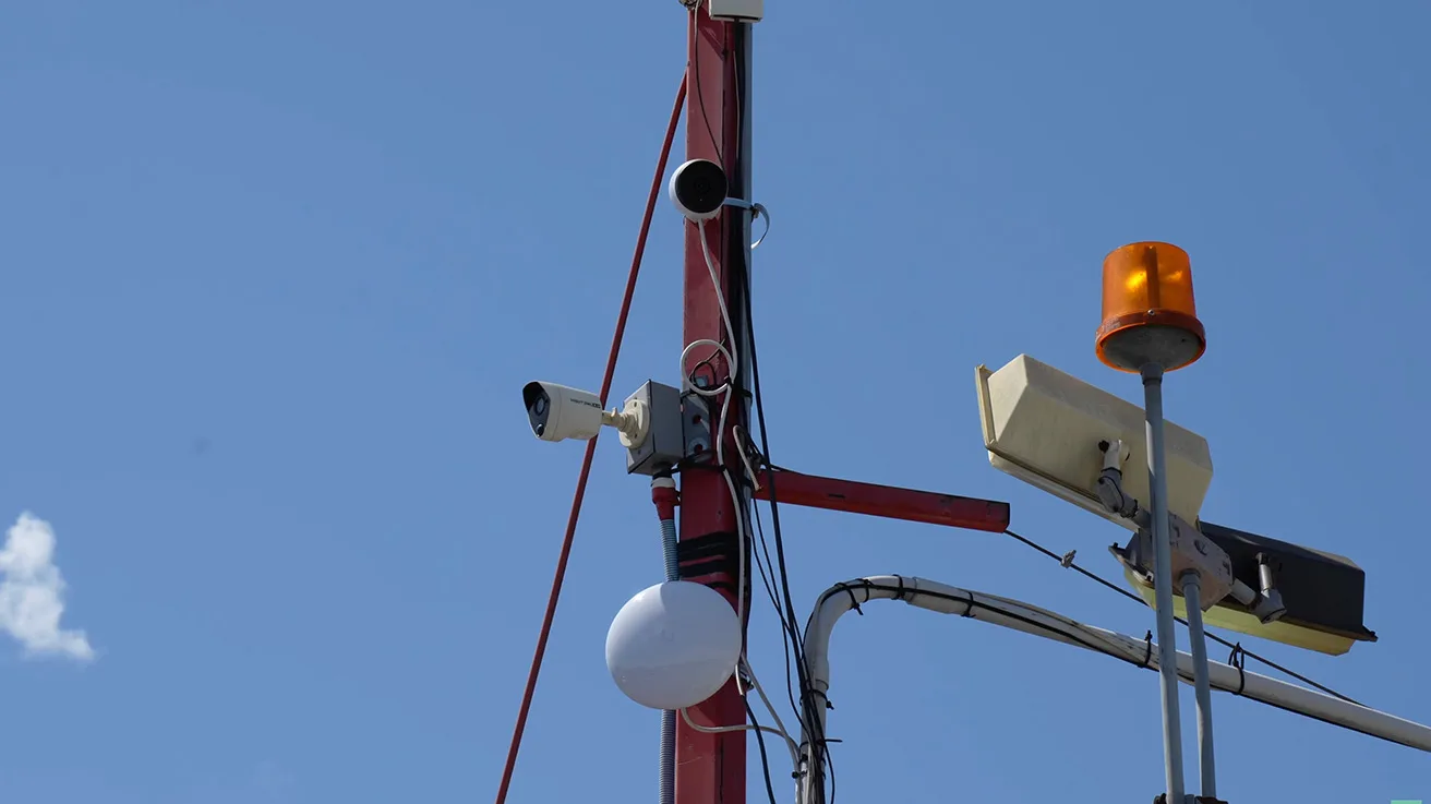 Ubiquiti access point and UniFi security camera mounted on a high pole at a commercial facility
