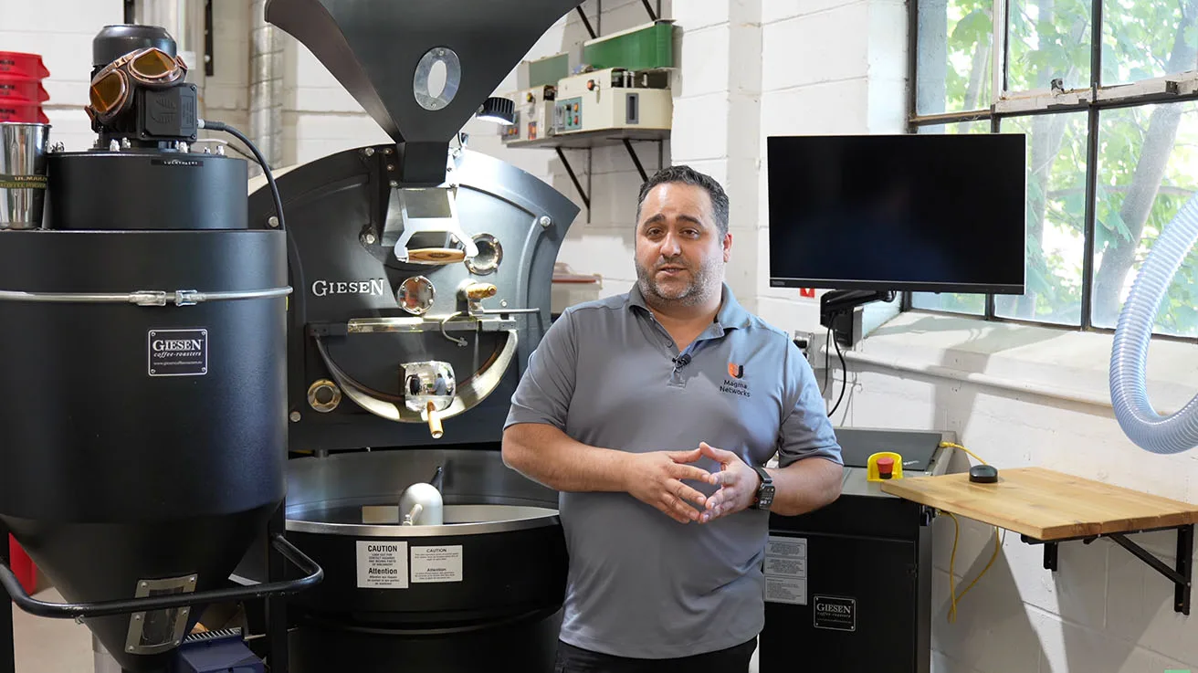 Security integrator presenting Ajax Hub 2 Plus and wireless protection suite in coffee roastery
