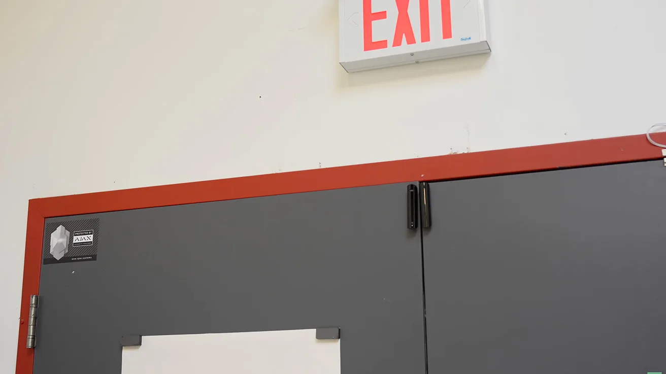 Ajax DoorProtect wireless opening detector installed on emergency exit door