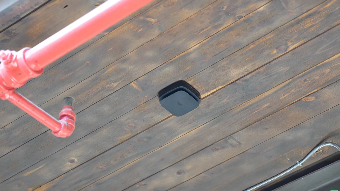 Ajax FireProtect 3-in-1 sensor installed on wooden ceiling in coffee roasting facility