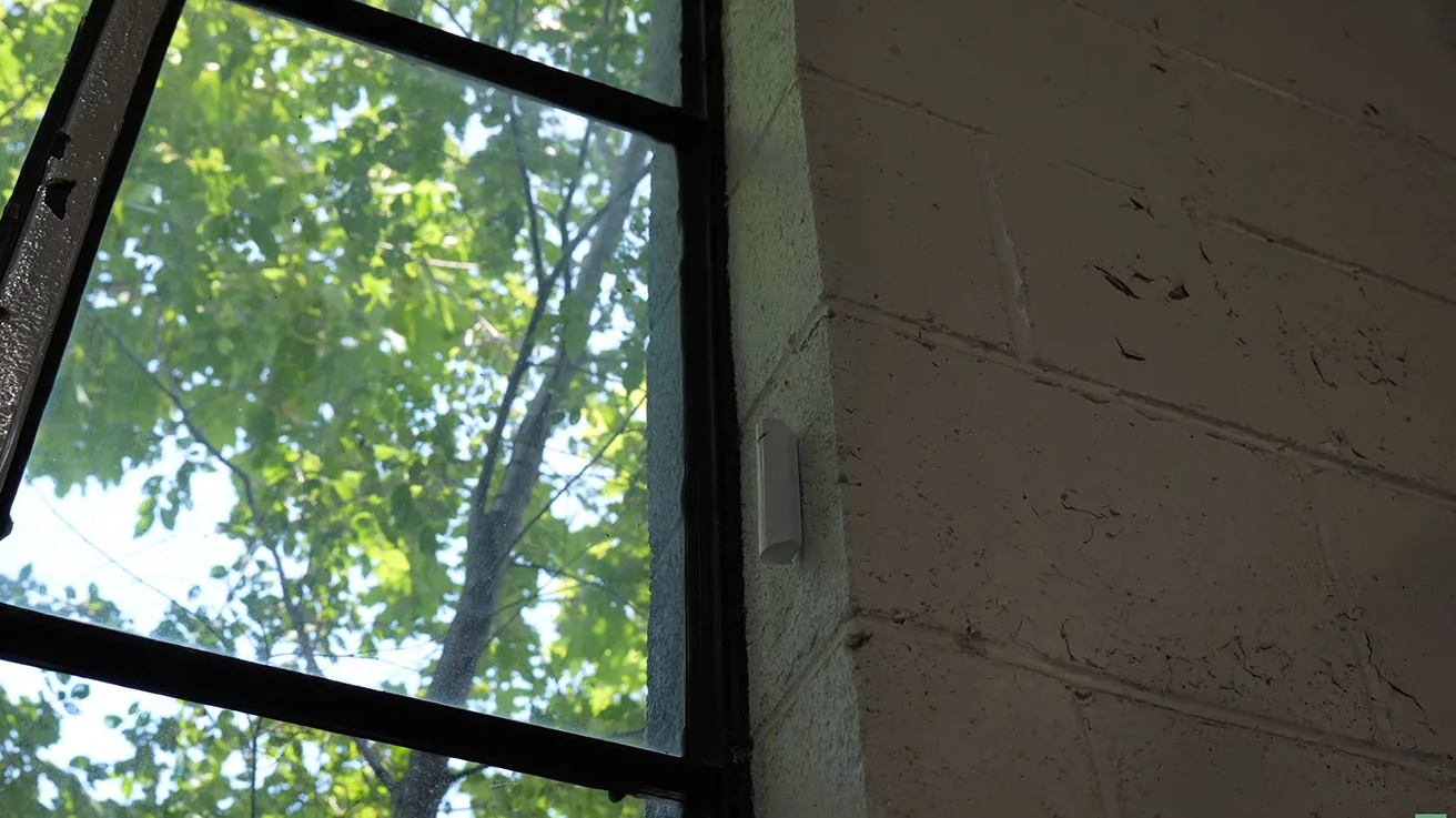 Ajax GlassProtect wireless sensor mounted on production area window