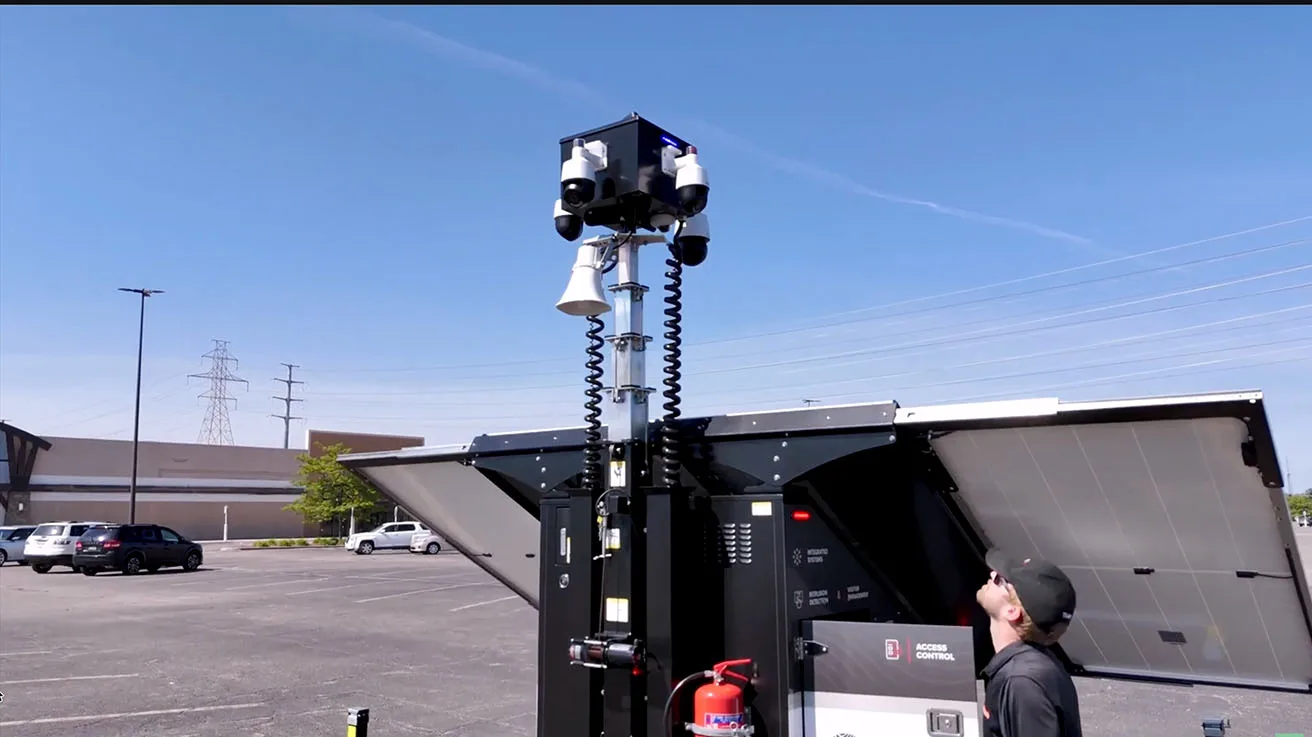 Autonomous mobile surveillance trailer with raised mast deployed in commercial parking lot