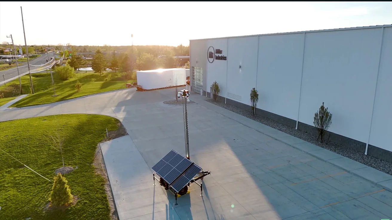 Aerial drone view of mobile security trailer providing 360 degree coverage on industrial property