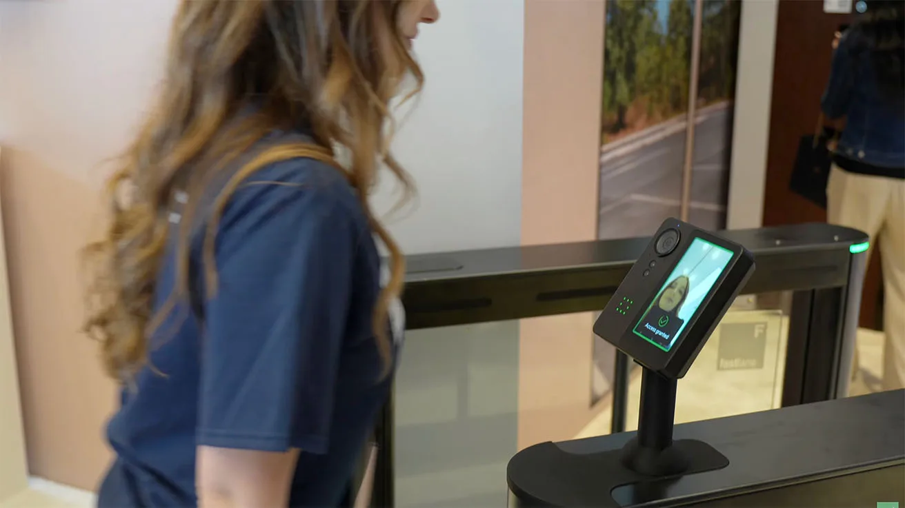 Employee passing through a security turnstile using the Verkada AF64 face unlock reader.