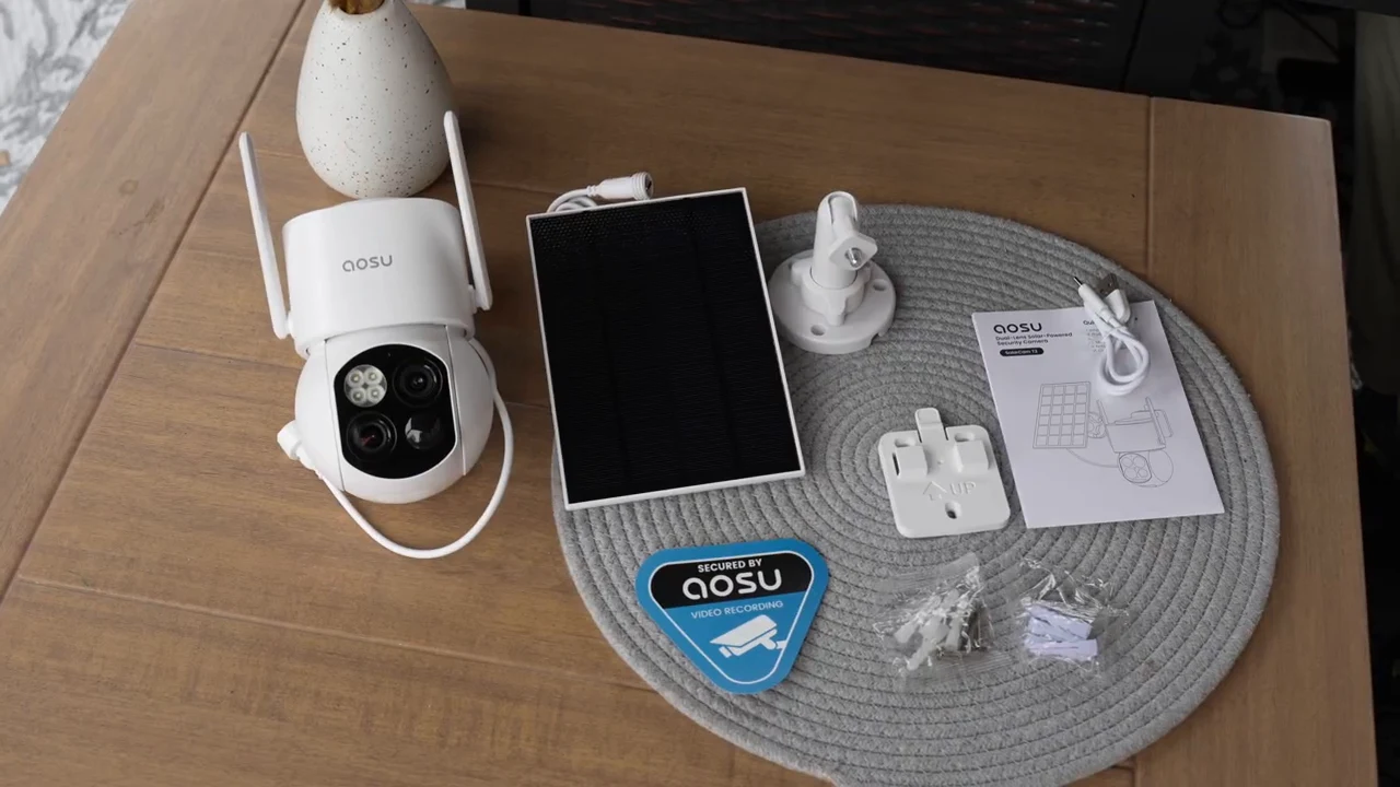 aosu SolarCam T2 camera, solar panel, mounting accessories, cable, and guide arranged on a table