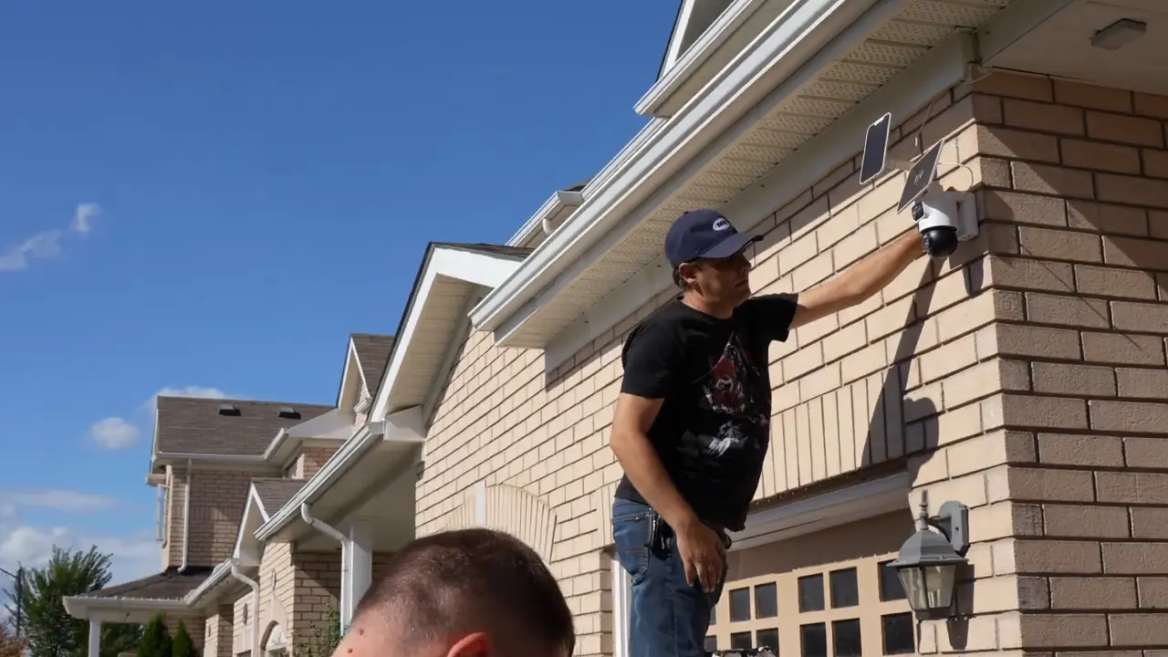 Installer positioning the Reolink OMVI 2i Ultra above the driveway