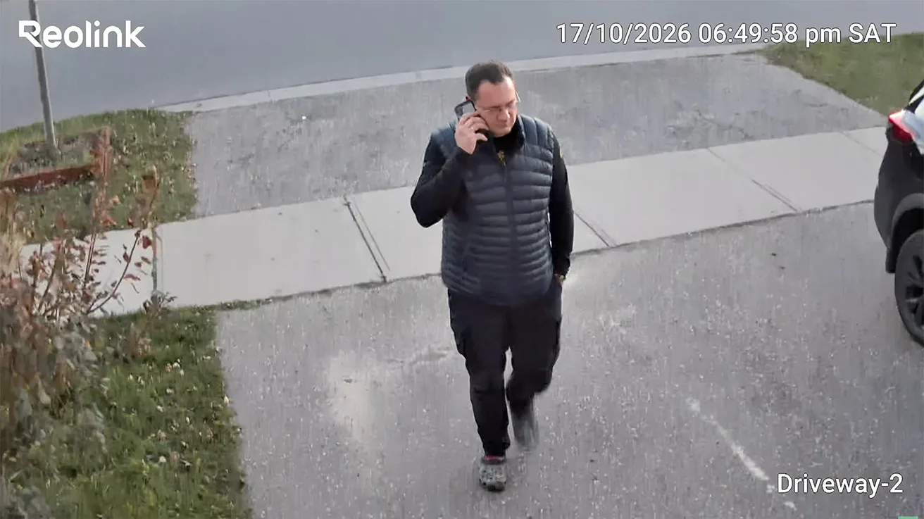 Tracking view following a person near parked cars