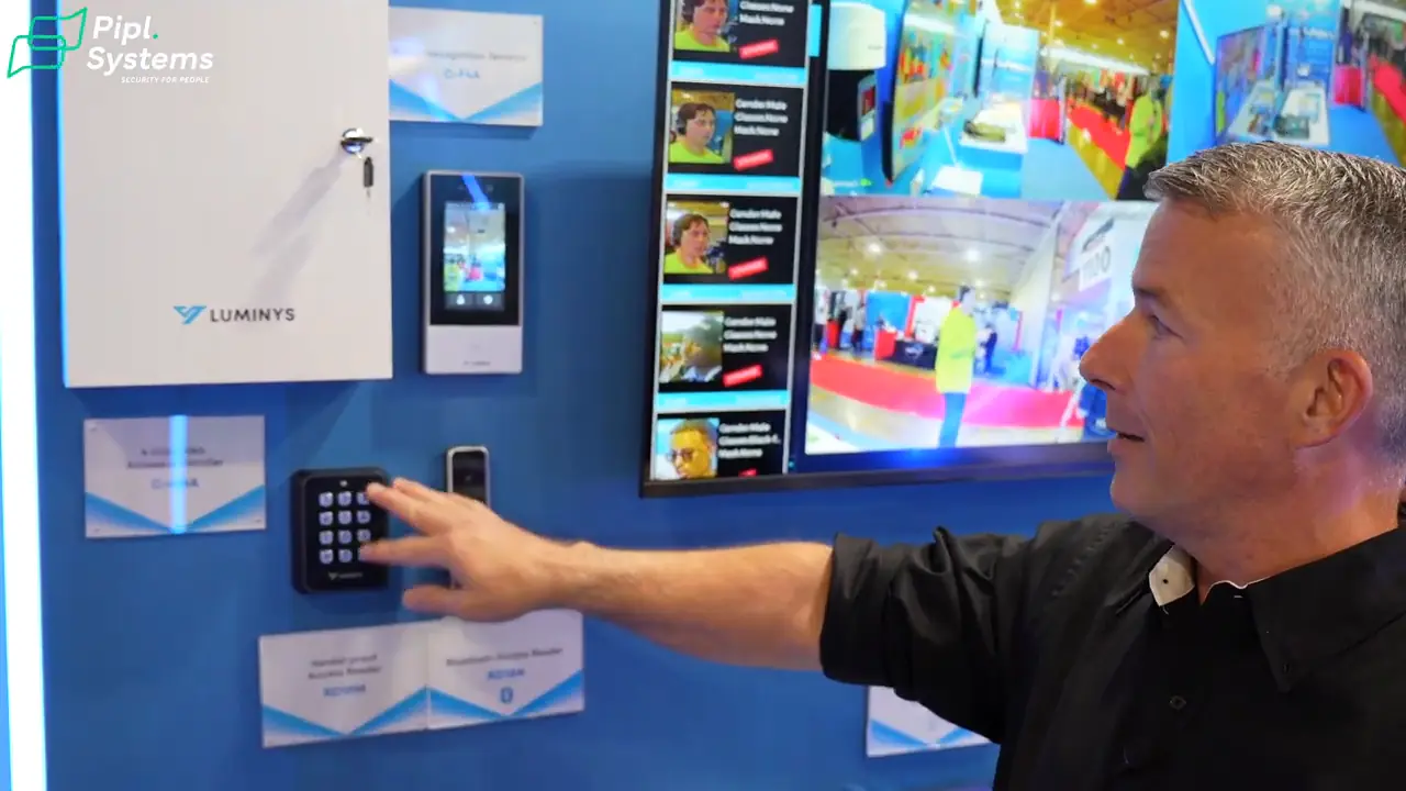 Chris Robertson indicates a keypad beside a facial recognition terminal and access control cabinet.