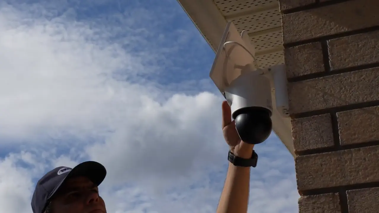 Installer holding the OMVI 2i Ultra with its two camera modules visible